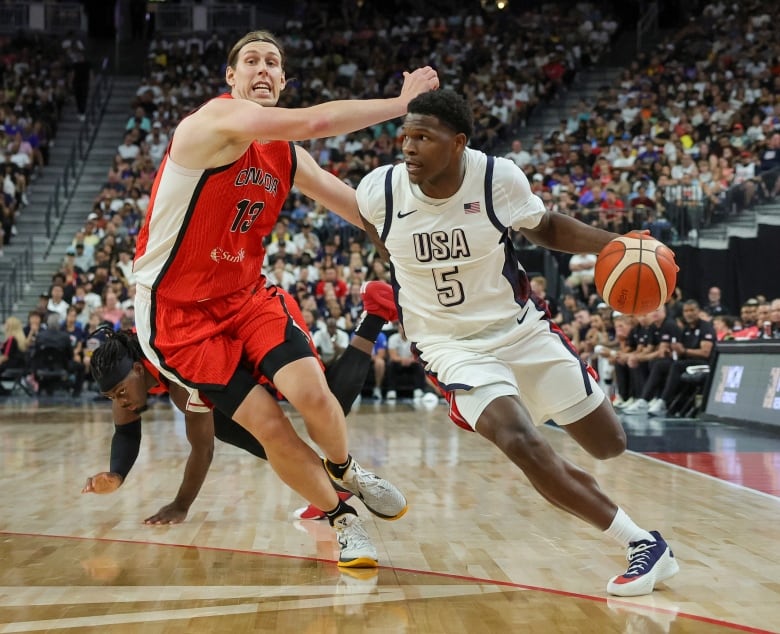 A basketball player drives past an opponent.