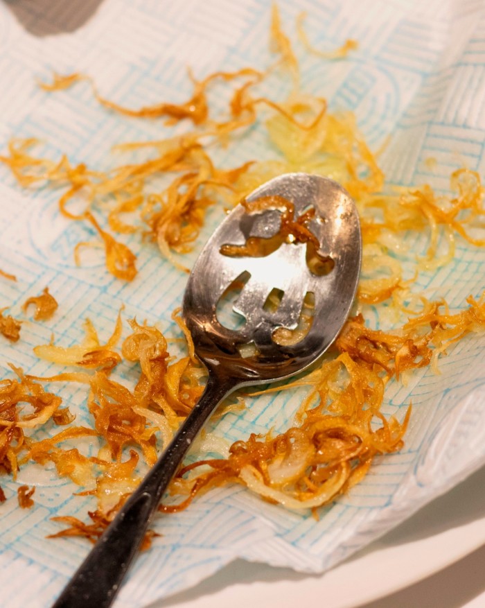 A close up of a spoon and fried onions