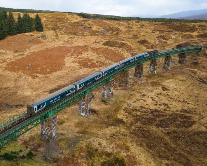 The Caledonian Sleeper train crossing a viaduct across a Scottish moor