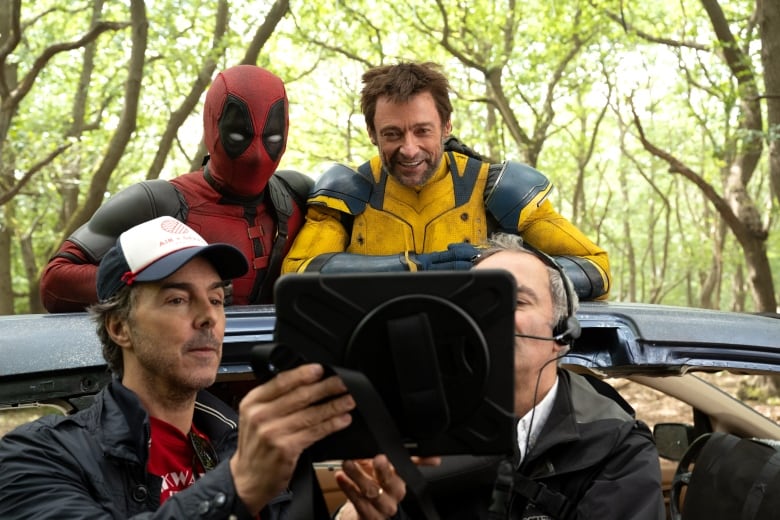 Director Shawn Levy shows Ryan Reynolds, and Hugh Jackman a screen on set of Marvel Studios' Deadpool and Wolverine.