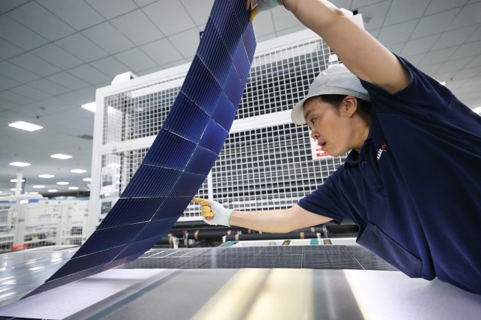 An employee works on the production line of solar panels for export in Lianyungang, Jiangsu province of China