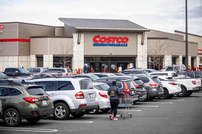 Cars are in the foreground of a Costco warehouse store.