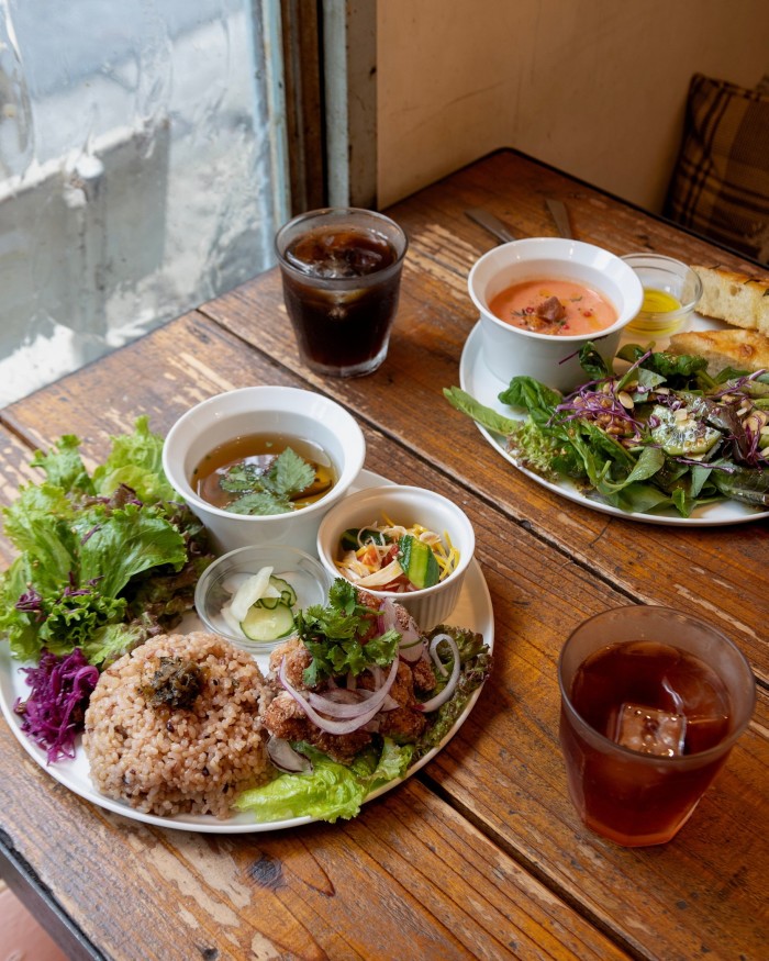 The café’s brown-rice platter: soy karaage, vegetable stir-fry, pickles, soup and salad, with a glass of ice tea