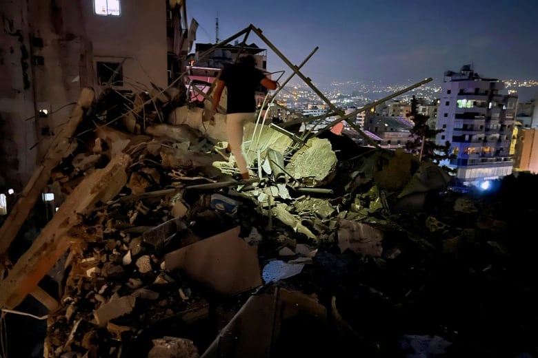 A man walks along a section of a building damaged in an Israeli airstrike on Tuesday evening.