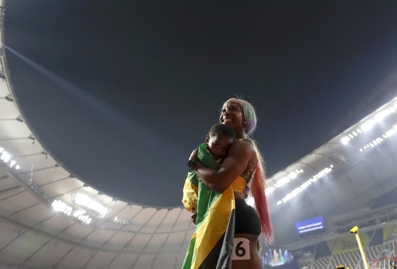 An athlete holds a baby on the track