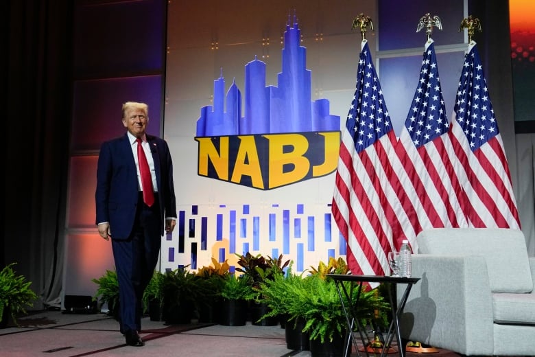 Former U.S. president Donald Trump is seen walking on stage at the Chicago-hosted NABJ event on Wednesday.