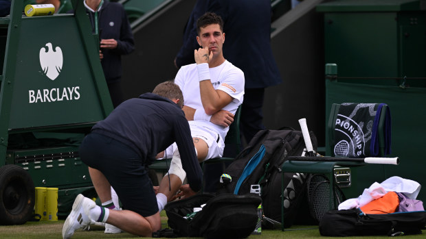 Thanasi Kokkinakis of Australia receives medical treatment before retiring injured.