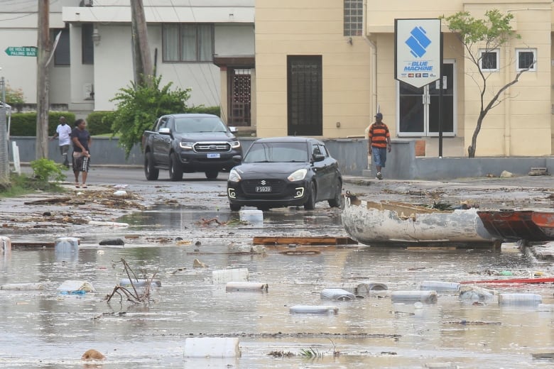 Puddles of water and storm wreckage on the street.