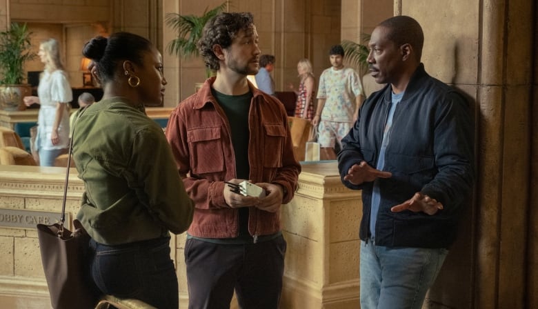 three people talk while standing in a courthouse