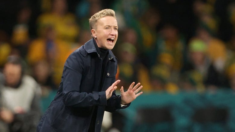 Soccer coach gestures while watching game