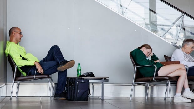 Airline passengers wait at Toronto's Billy Bishop airport after Porter Airlines cancelled flights on account of a global cybersecurity software failure that caused a series of cascading problems.