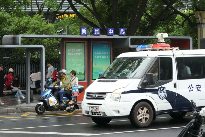 A police van at a bus stop in Suzhou where a woman and her son were stabbed