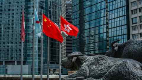 The flag of the Hong Kong Special Administrative Region, right, flies alongside the flag of China outside the Exchange Square complex in Hong Kong