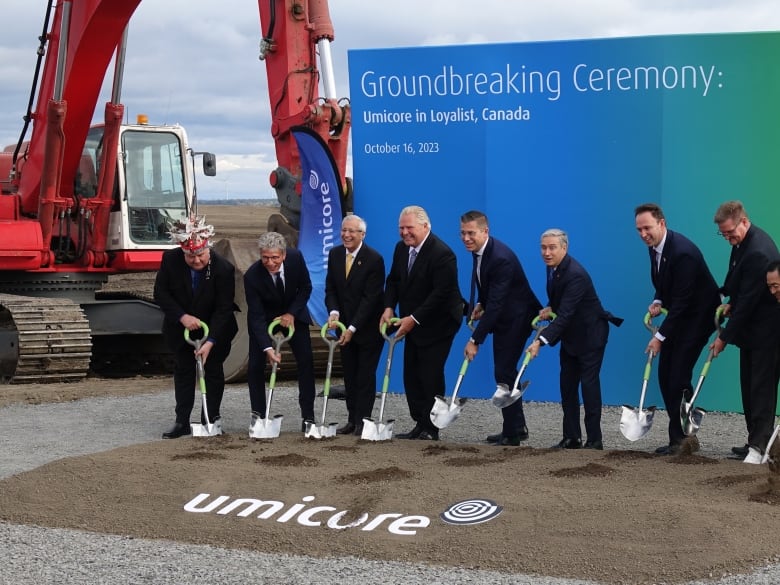 people posing with shovels in hand