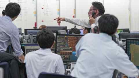 brokers at work at the trading floor of Tokyo Tanshi Co. in Tokyo, Japan