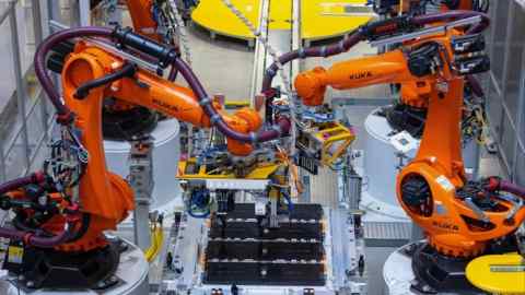 Robotic arms move batteries in a car factory in Germany