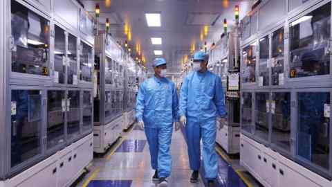 Two employees walk down the hallway of an SK On battery factory in South Korea