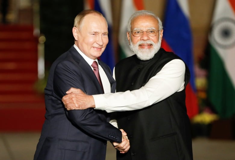 Two men shake hands.