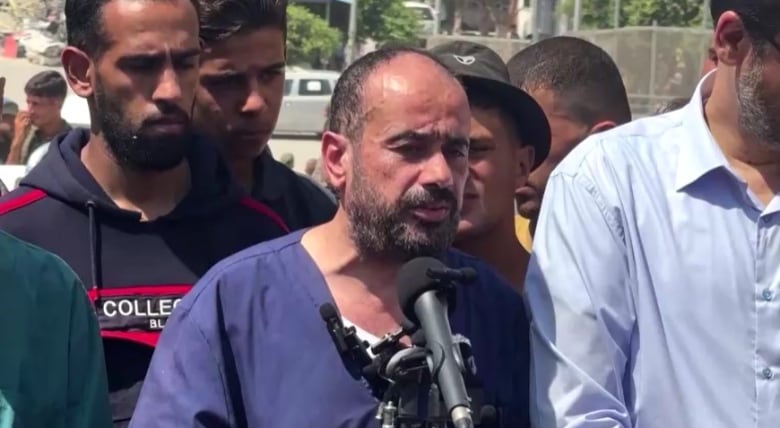 A doctor in Gaza speaks into a microphone.