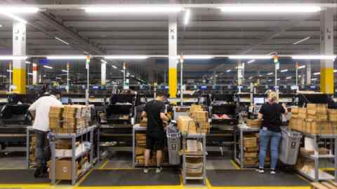 Staff members stand packing goods into boxes