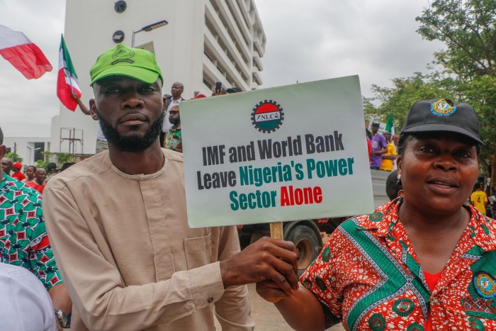 A protest in Abuja, Nigeria. One protester holds a sign reading ‘IMF and World Bank leave Nigeria’s power sector alone’  