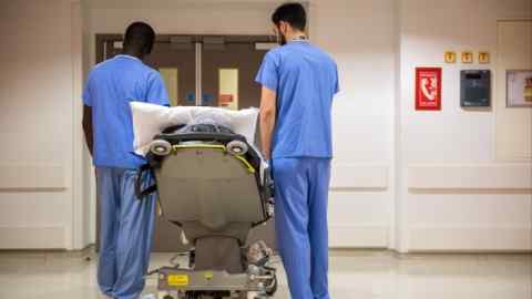 Medical staff accompany a patient on a trolley at the Royal London Hospital