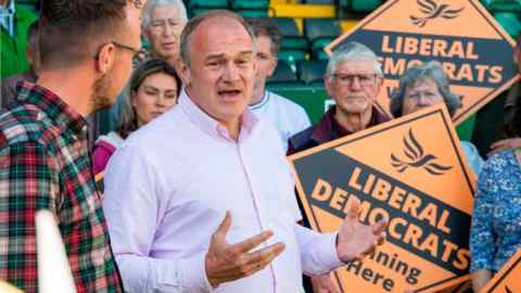 Ed Davey with party activists carrying Lib Dem posters