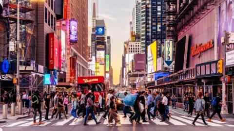 People crossing the street near Times Square at sunset