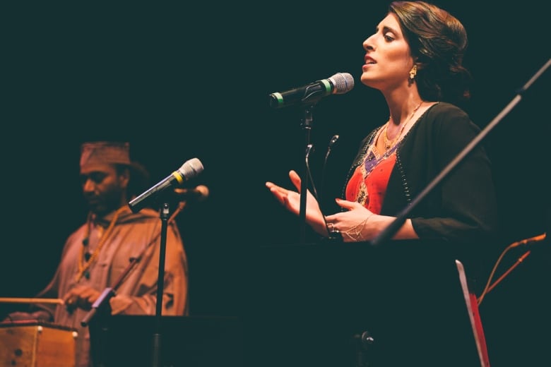 A woman performing at a microphone. 