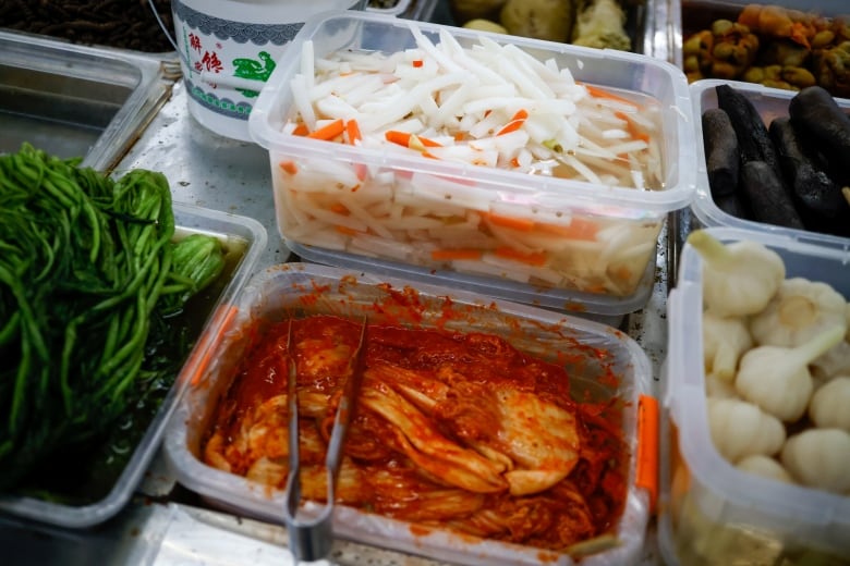 Korean pickled cabbage and Chinese pickled vegetables are in plastic containers.