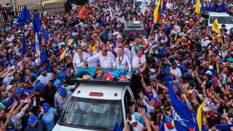 Presidential candidate Edmundo Gonzalez and opposition leader Maria Corina Machado greet supporters from the back of a truck during a campaign rally in Maracaibo on Tuesday