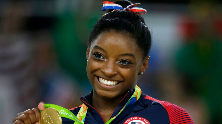 FILE - United States gymnast Simone Biles displays her gold medal for floor during the artistic gymnastics women's apparatus final at the 2016 Summer Olympics in Rio de Janeiro, Brazil, Aug. 16, 2016. The 27-year-old Biles is returning for a third Olympics, where she will try to earn an all-around gold to bookend the one she captured in 2016 in Rio. (AP Photo/Rebecca Blackwell, File)