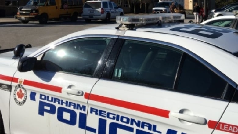 A white Durham Regional Police Service car with blue and red accents.