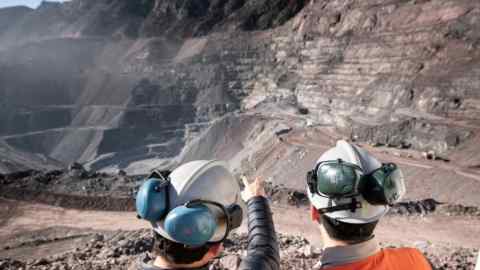 Two men stand in front of Anglo American’s El Soldado copper mine