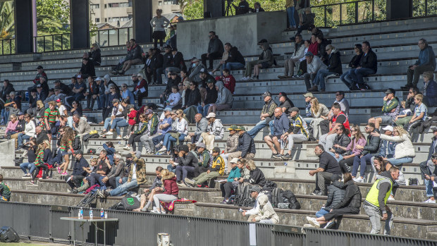 A crowd watches a junior rugby league game.