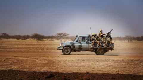 Armed soldiers on board a pick-up truck