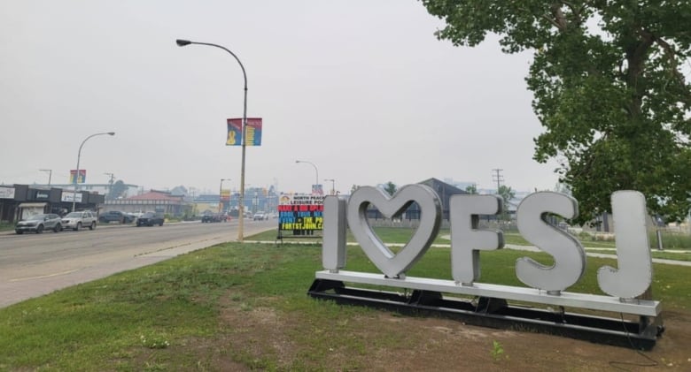 A road sign that reads "I Heart FSJ" along a highway with smoky skies.