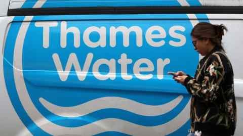 A pedetsrtain walks past a Thames Water vehicle