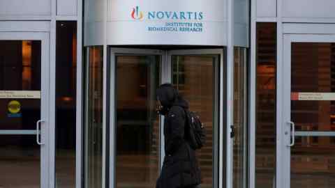 A pedestrian passes by Novartis’ Institutes for Biomedical Research