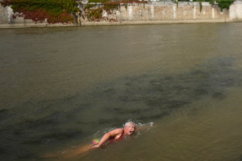 An elderly man swims in the Seine River