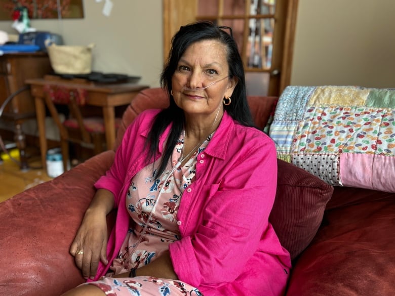 Woman with oxygen tubes smiles.