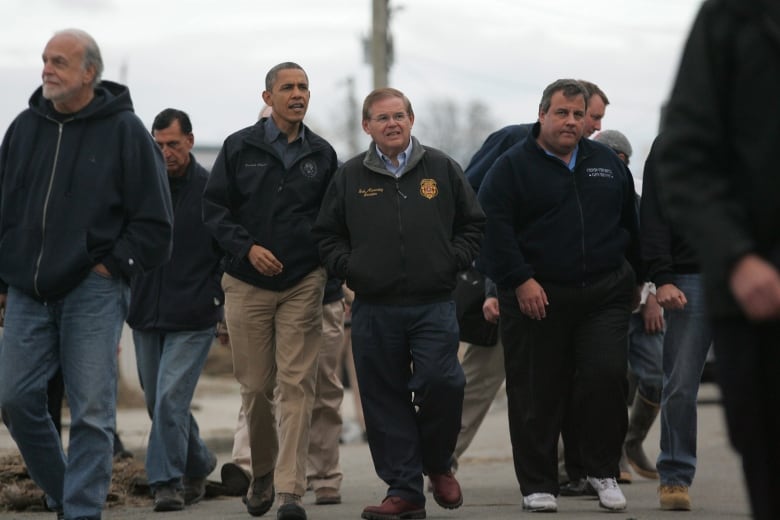 A group of people walk down the street.