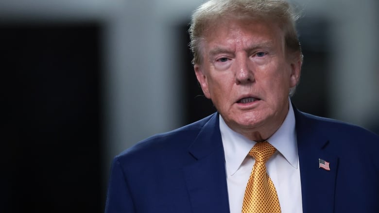 Former U.S. president Donald Trump is seen walking en route to speak with members of the media in New York City.