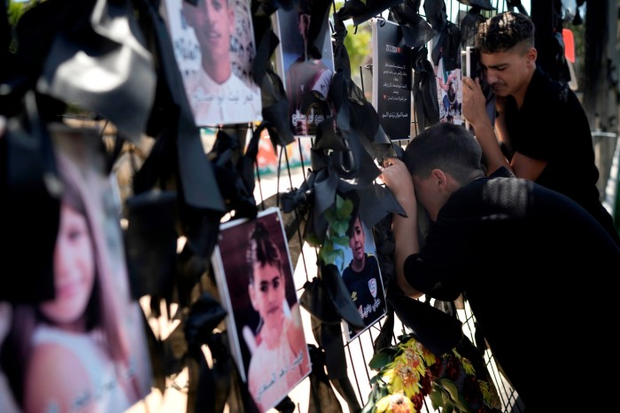 Young people from the Druze minority weep at a makeshift memorial in the village of Majdal Shams