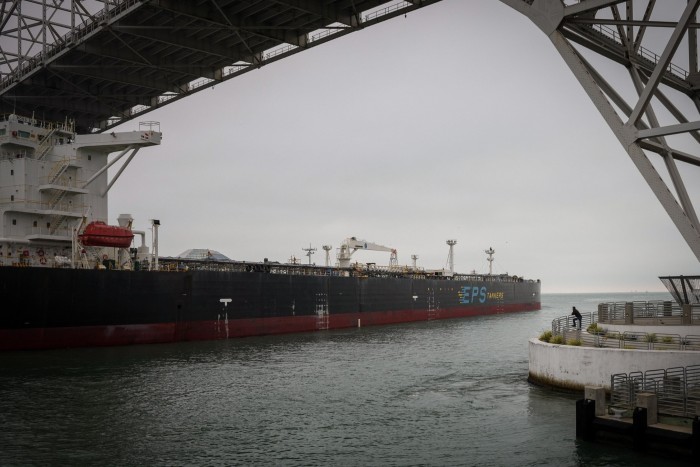 A man watches a ship pass under the Harbor Bridge as it leaves the Port of Corpus Christi on Thursday