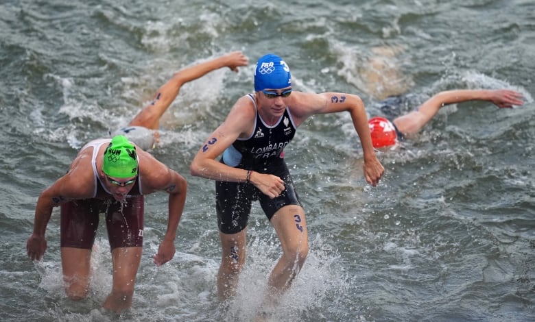 Two competive swimmers emerge from open water.