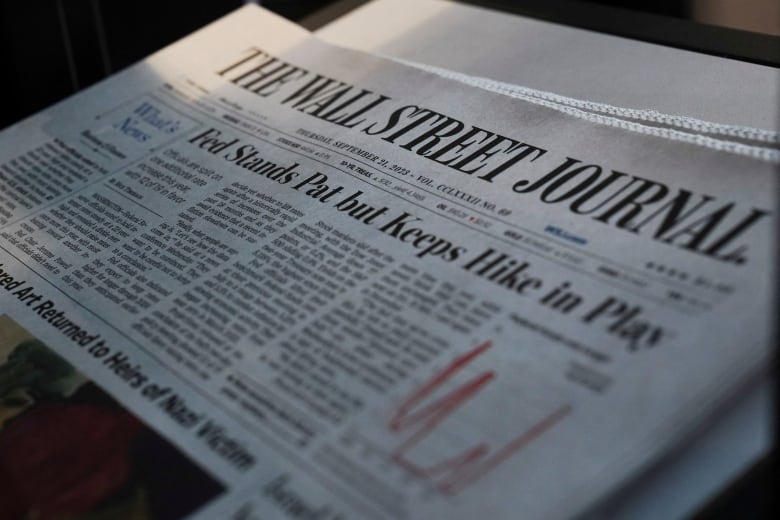 A copy of the Wall Street journal with the headline 'Fed Stands Pat but Keeps Hike in Play'