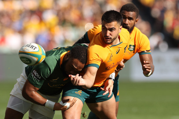 Tom Wright of the Wallabies offloads against the Springboks.