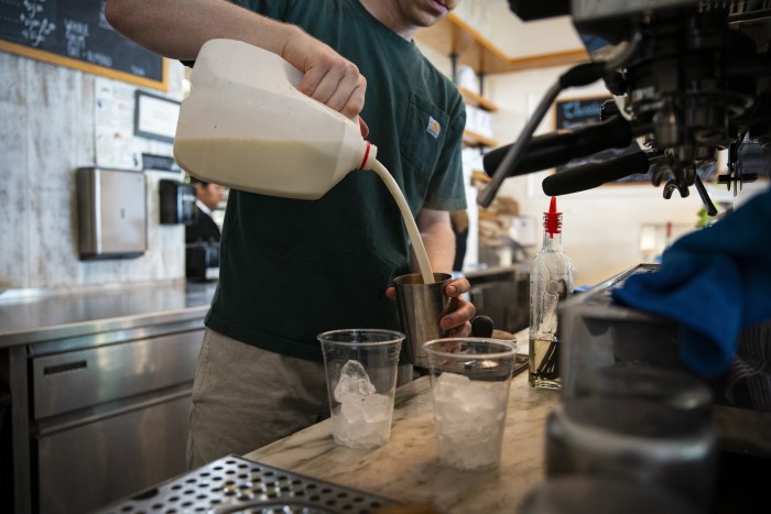 A barista pours milk for an iced latte at a coffee shop in the Union Market district in Washington, DC