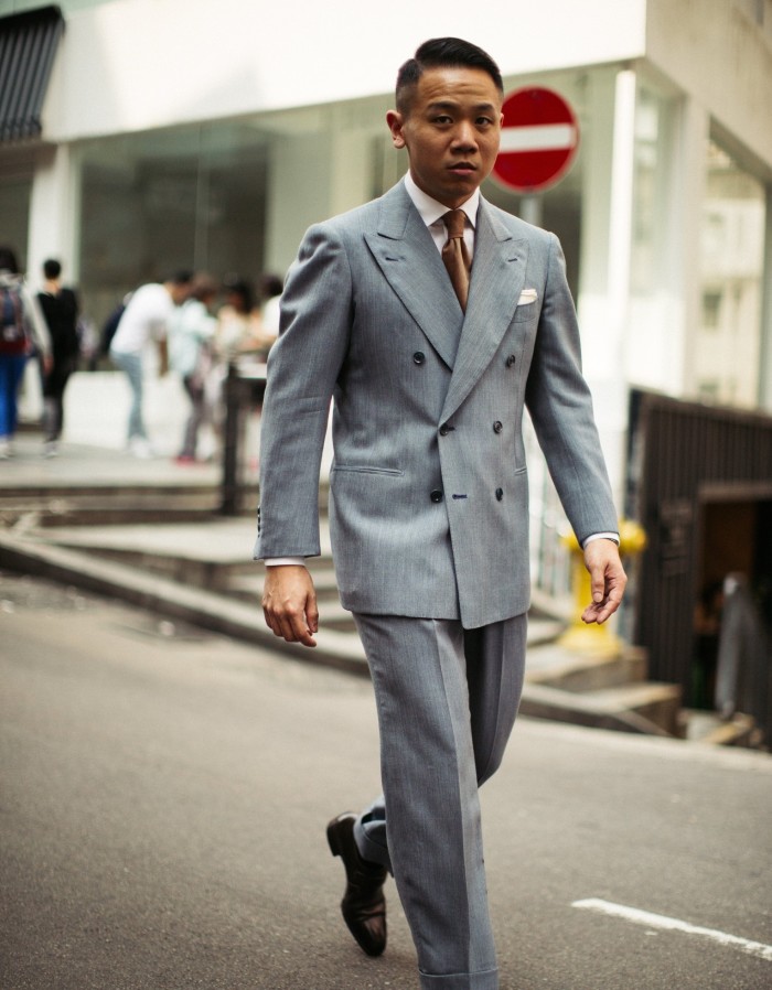 Jerry Wong of Hong Kong tailor Prologue walking down the street wearing a grey suit